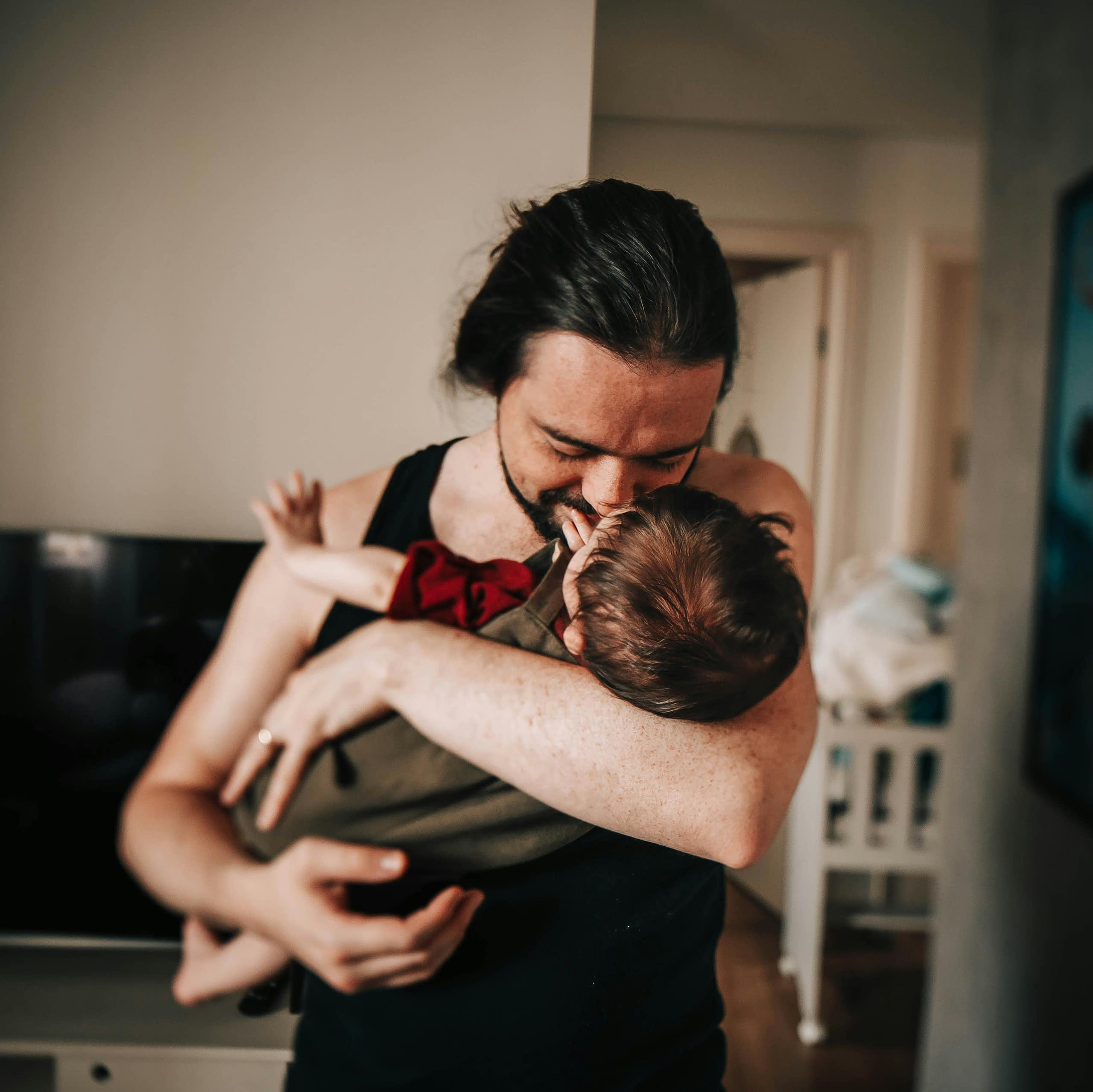 A father cradles a baby. 