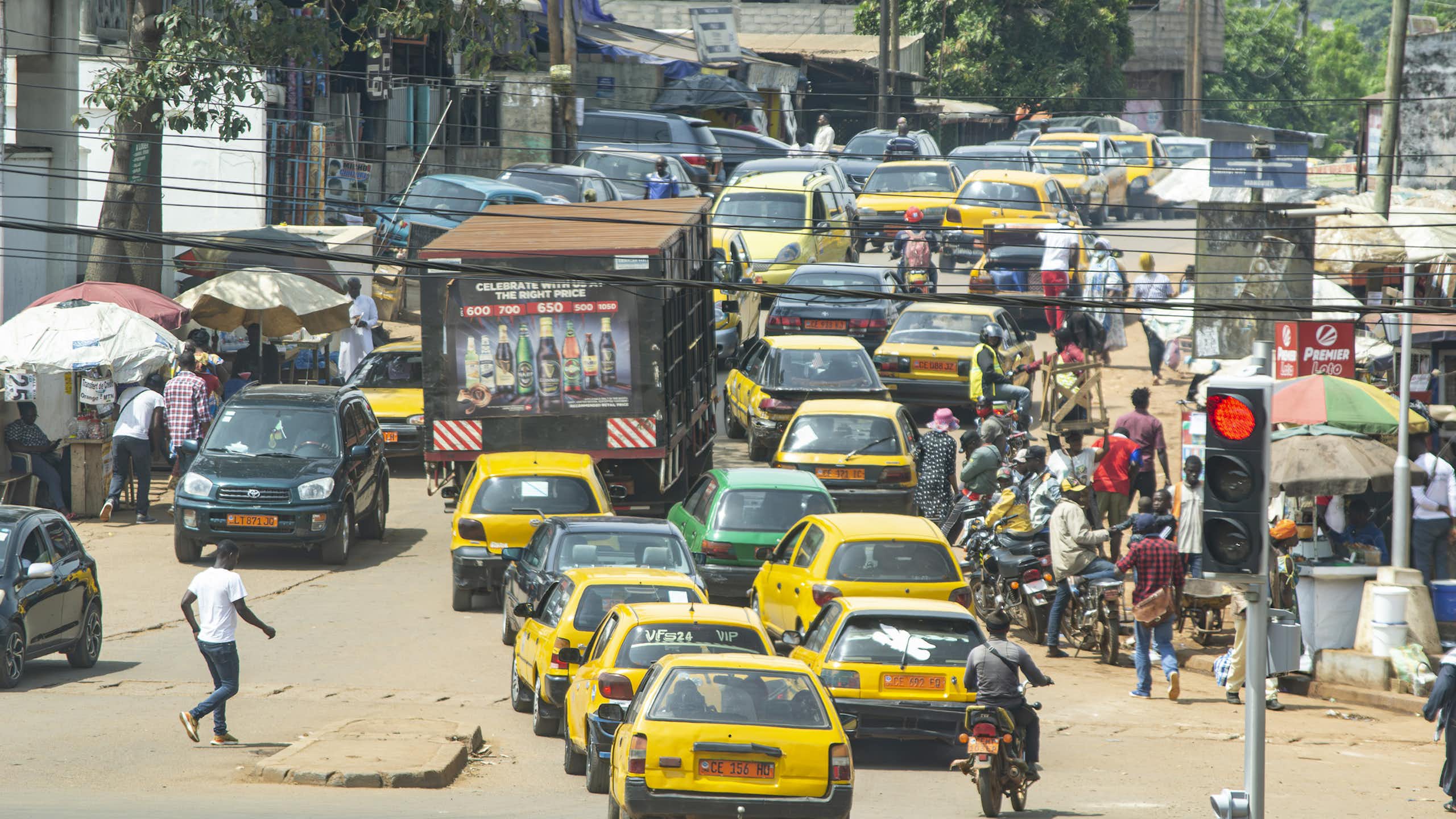 Busy urban road with cars, truck, motorcycles and pedestrians
