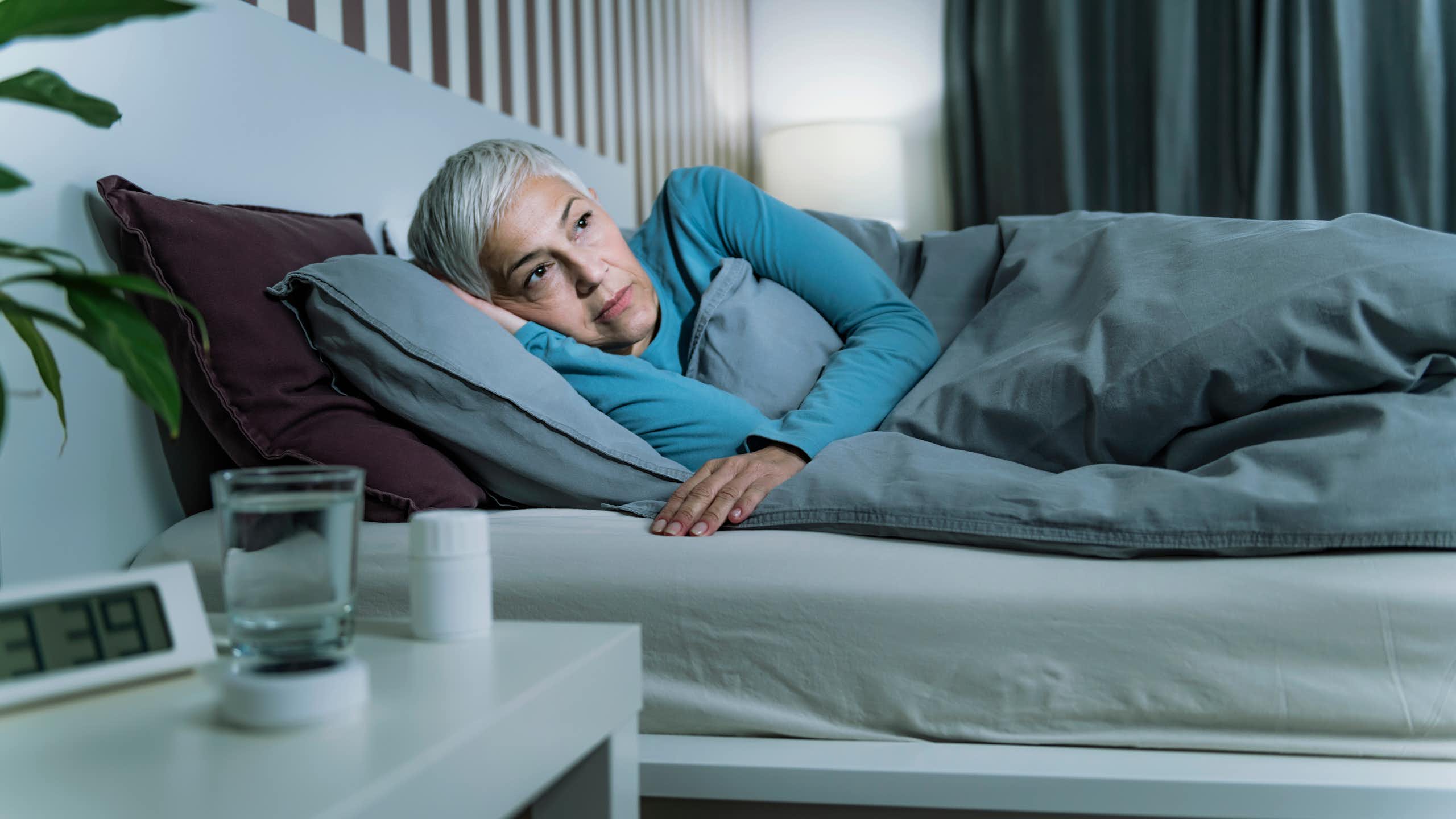 Uma mulher idosa na cama com os olhos abertos