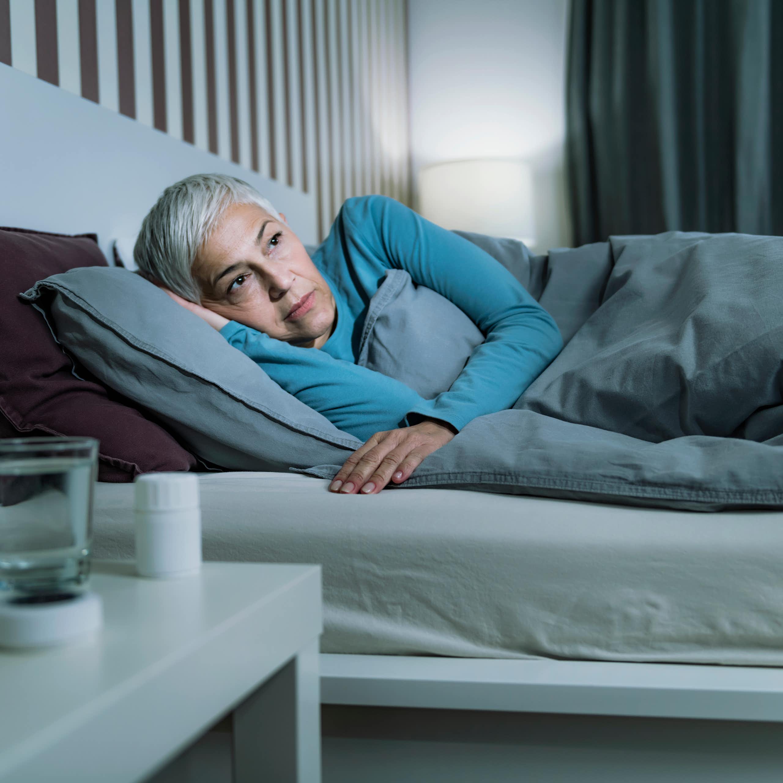 Uma mulher idosa na cama com os olhos abertos