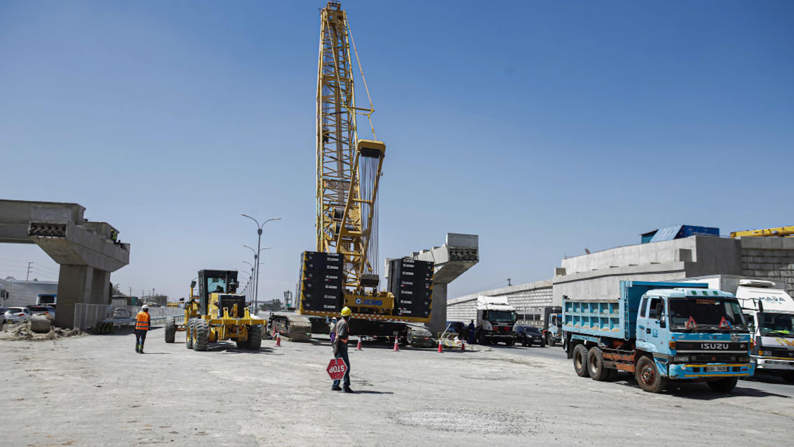 A worker helps direct traffic at a road construction site