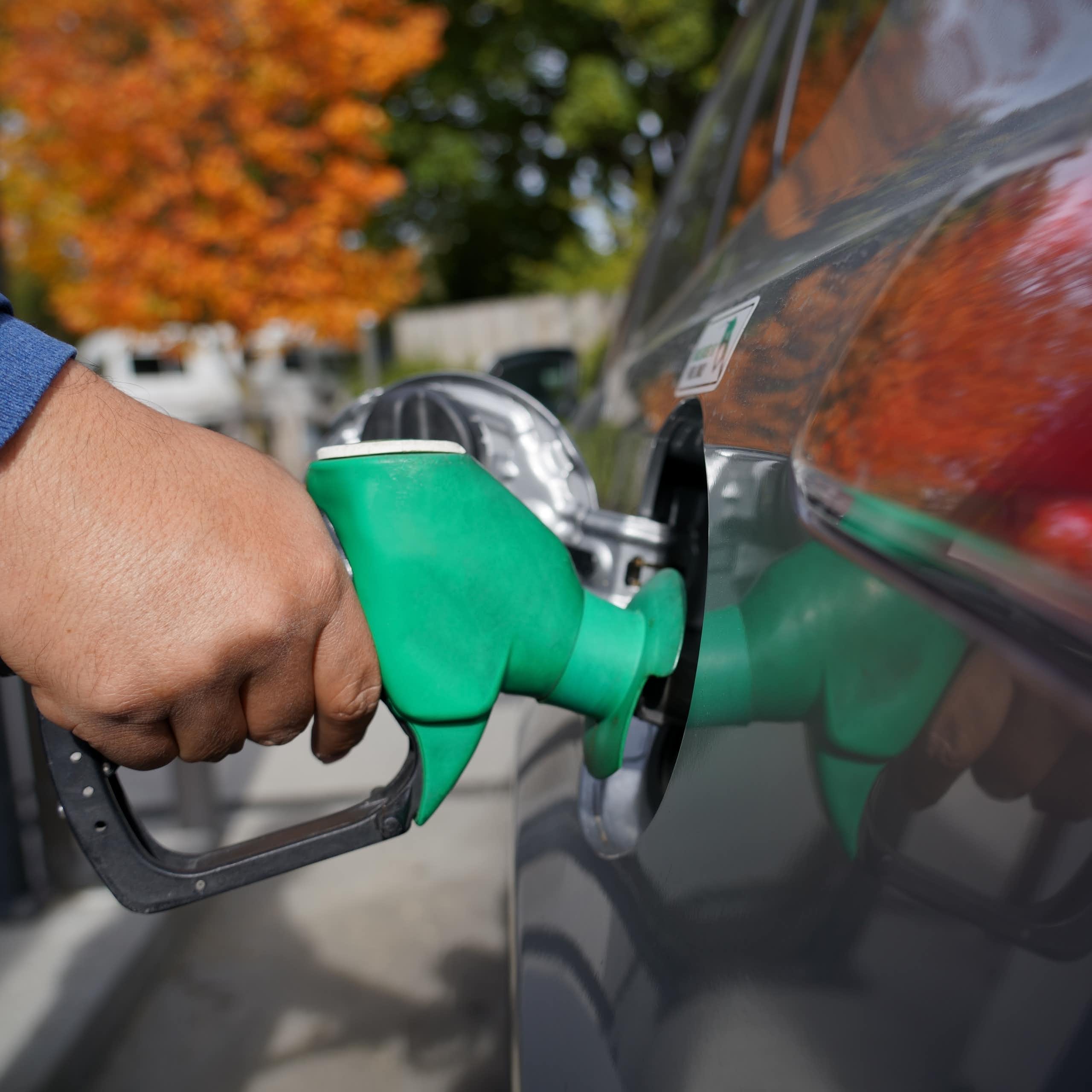 Detail of hand filling up a combustion engine car at the petrol station