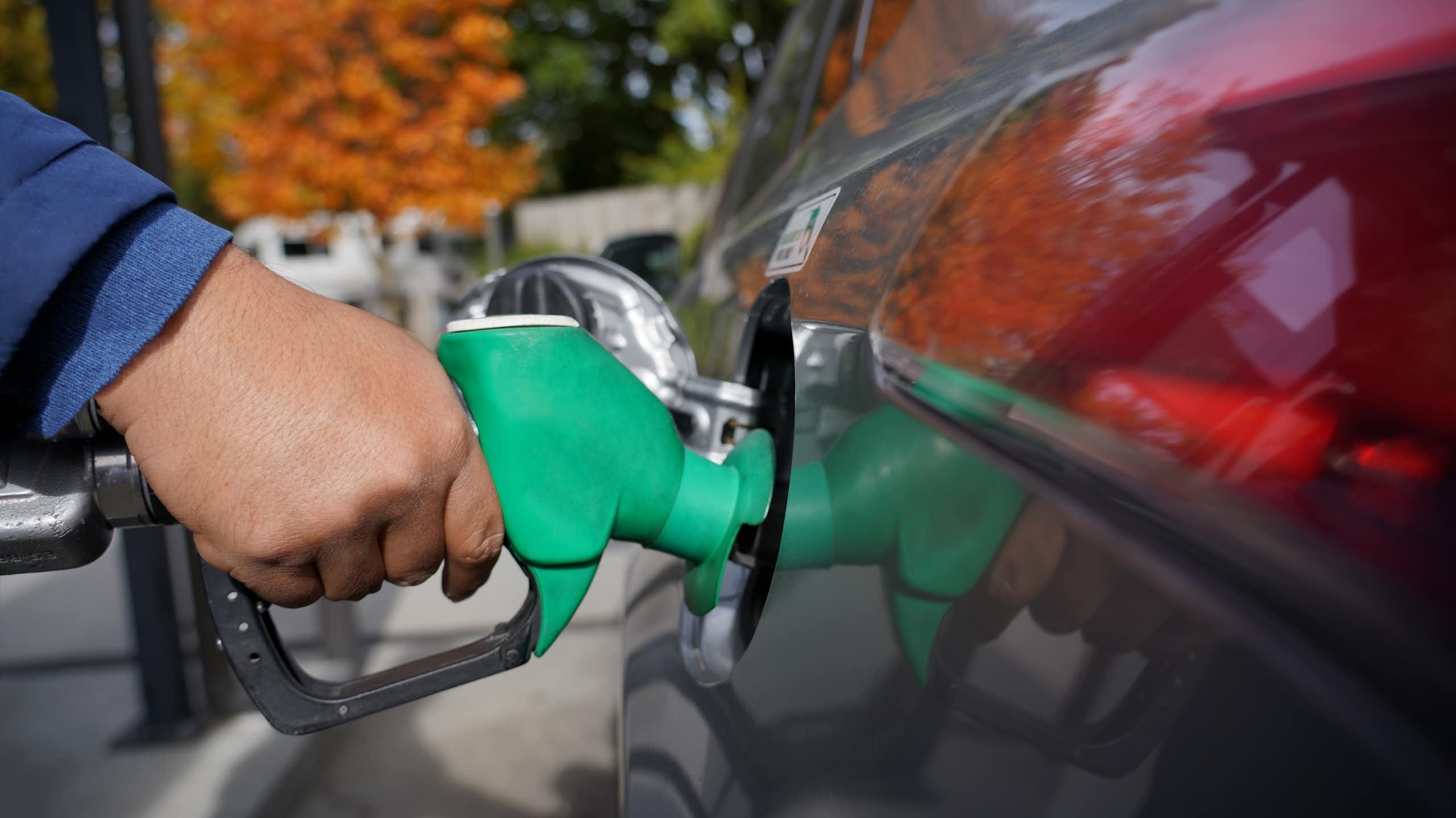 Detail of hand filling up a combustion engine car at the petrol station