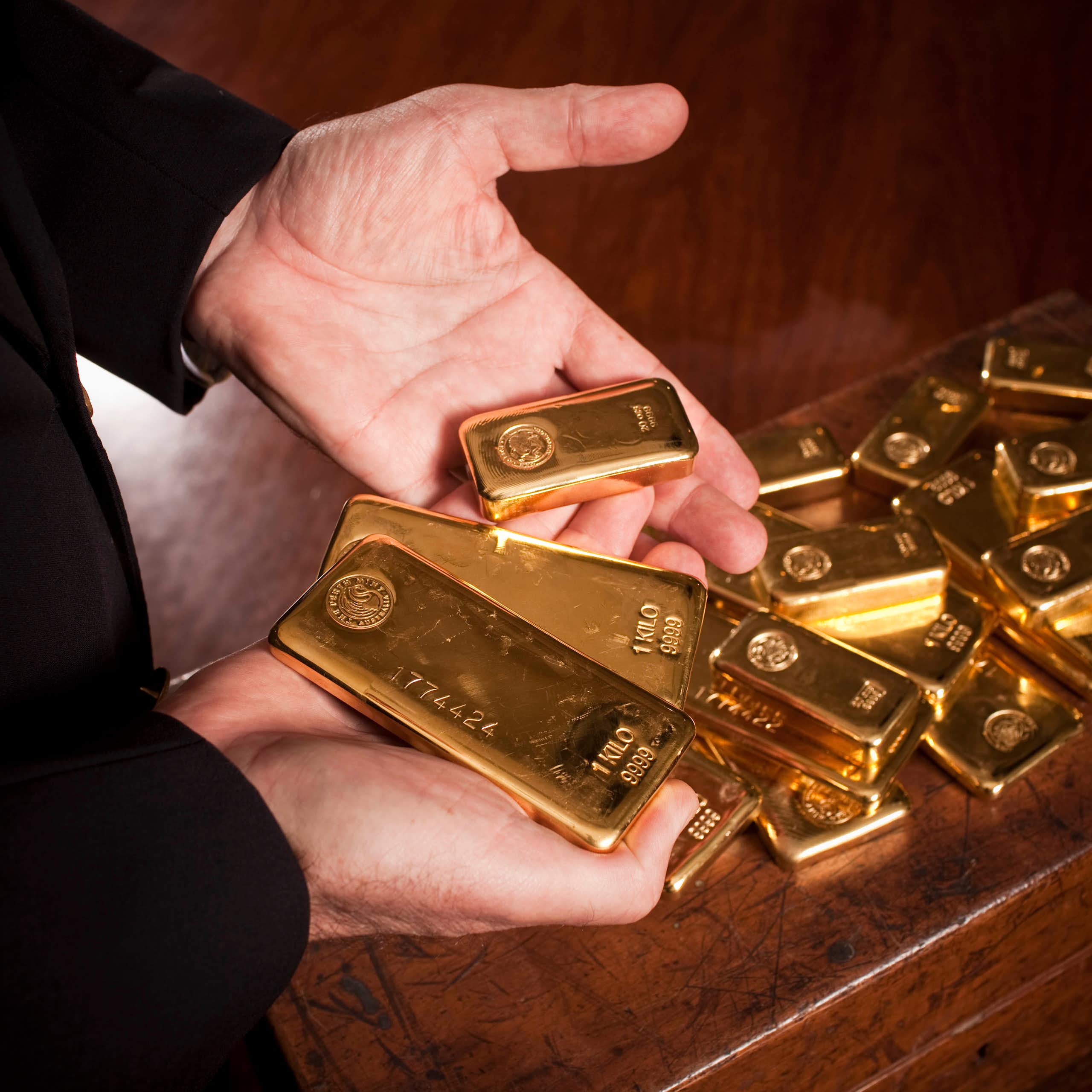 Person's hands holding gold bars