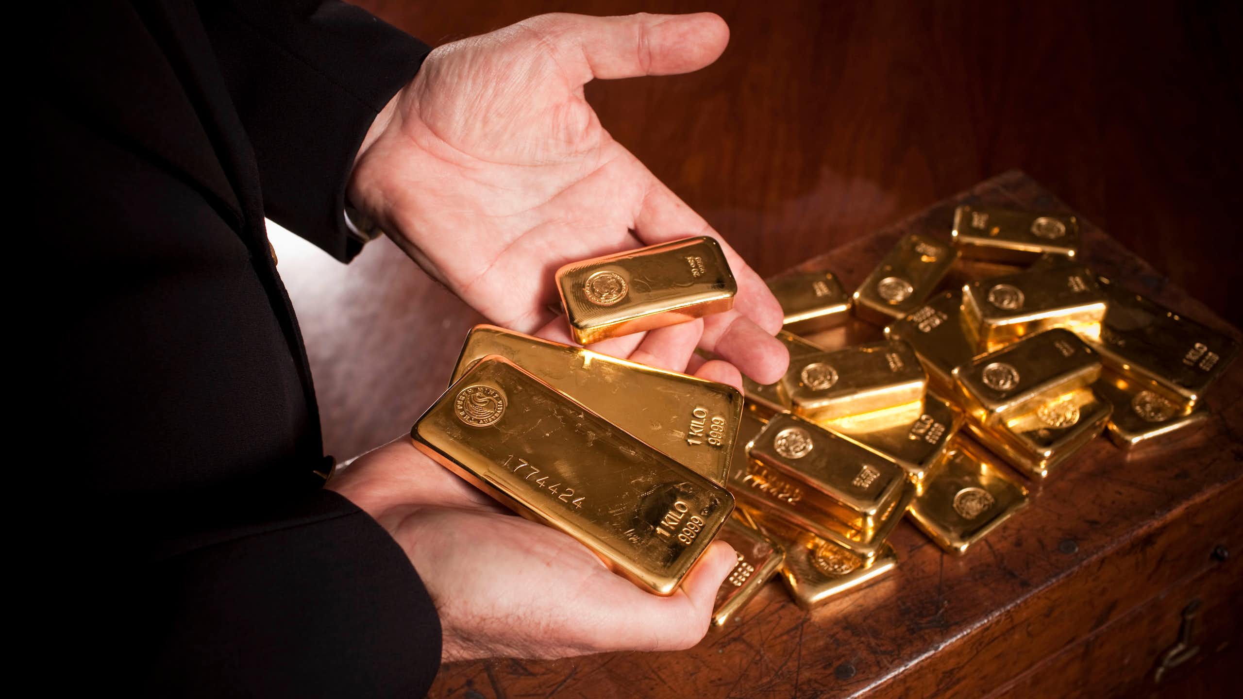 Person's hands holding gold bars