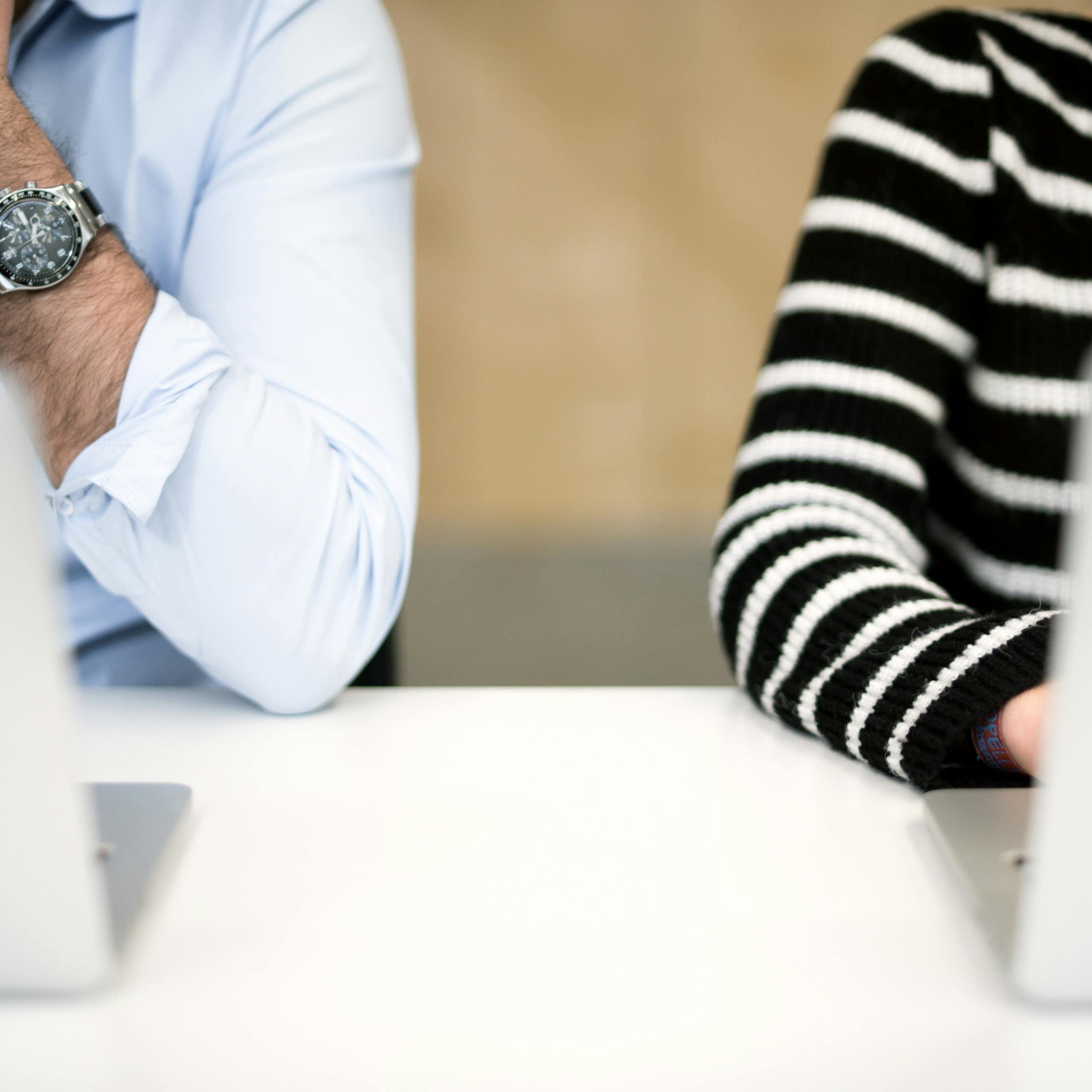 Photo of a man and woman sitting next to each other at computers