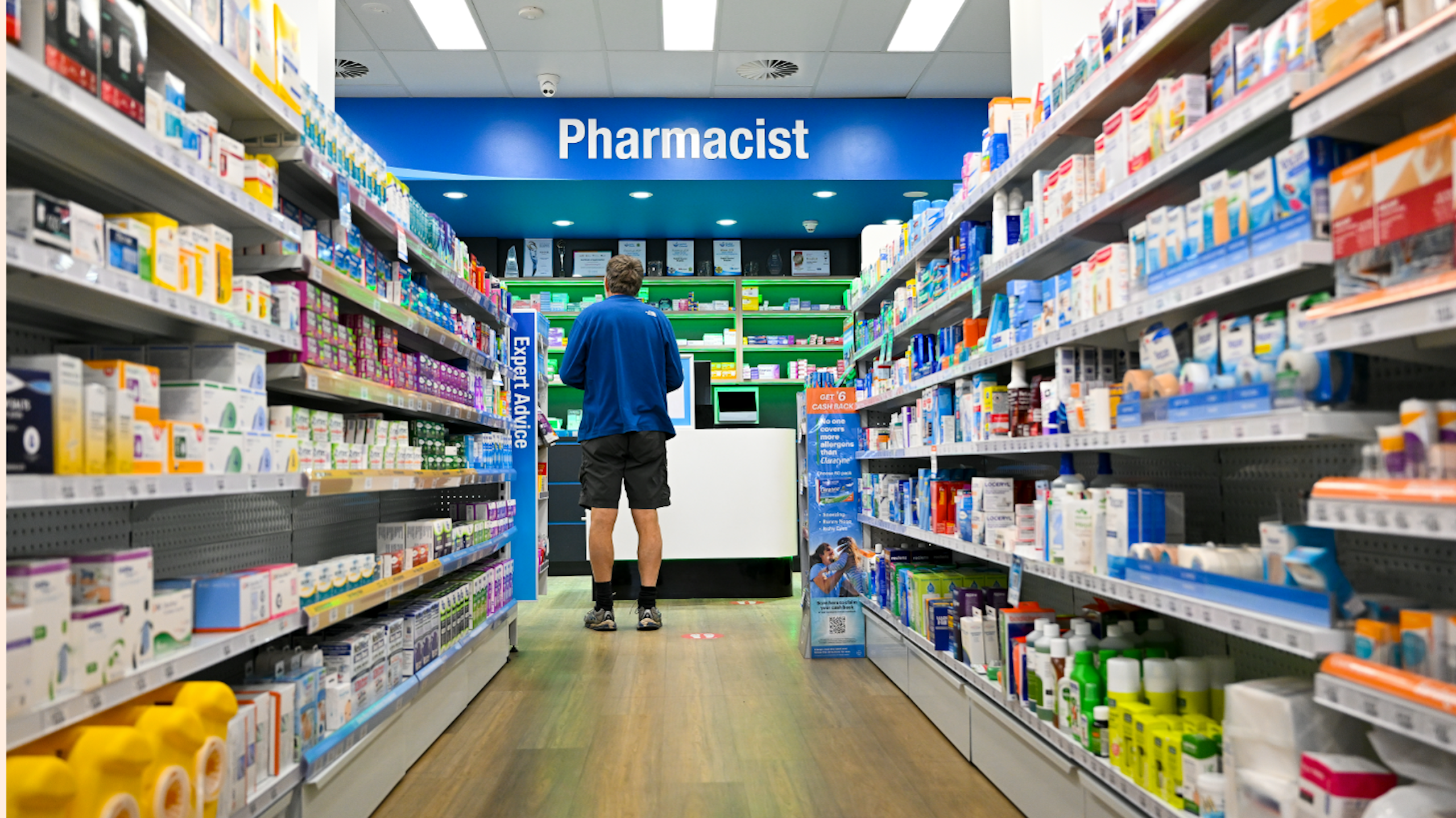 Man waits to get his prescription filled at a pharmacy